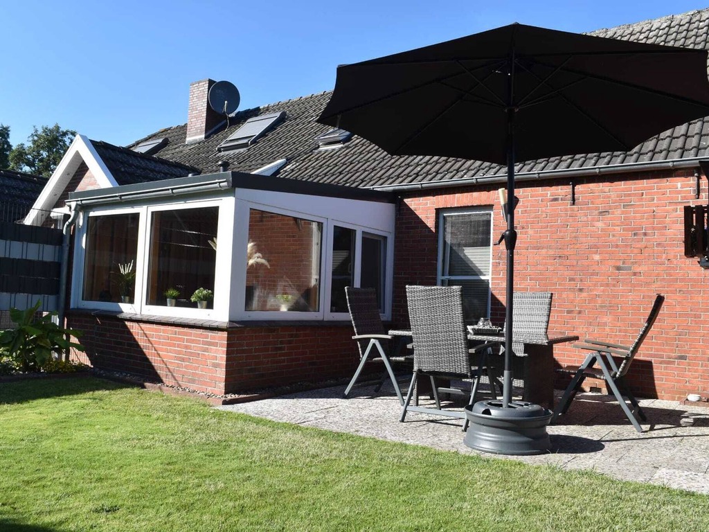 Außenansicht des Hauses mit Terrasse und Sonnenschirm